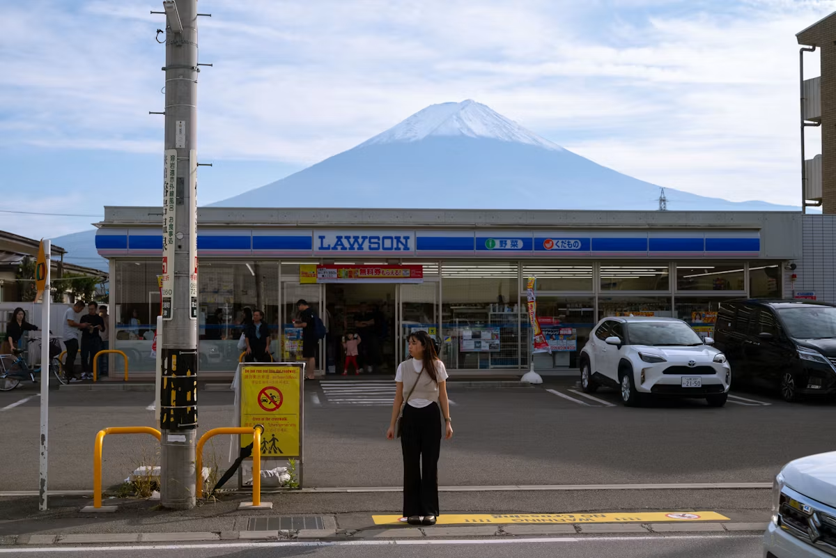 a girl standing in front of lawson, a japanese konbini