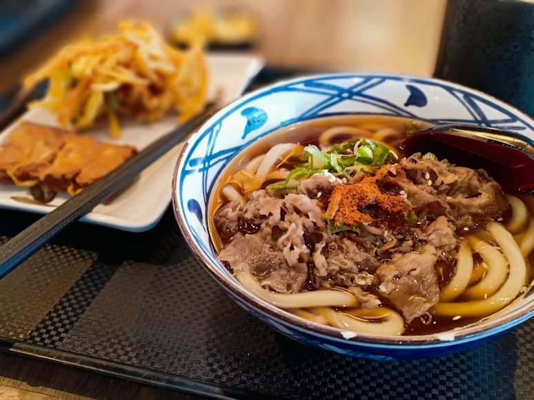 seporsi udon hangat dengan topping daging